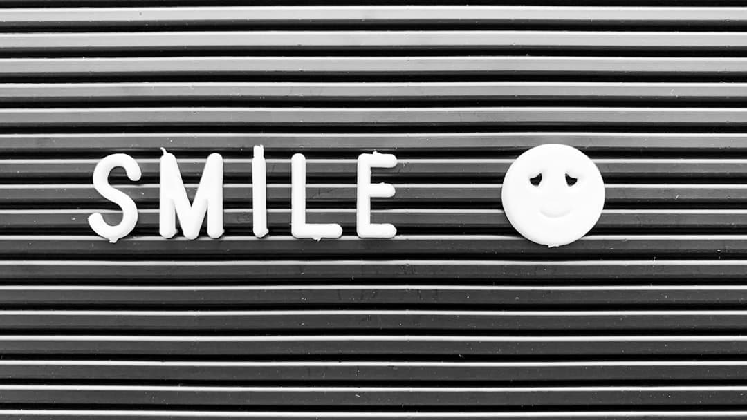the word smile written on a metal surface with a smiley face